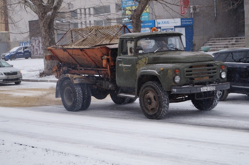 В Херсоне очищают дороги от снега и посыпают их песком